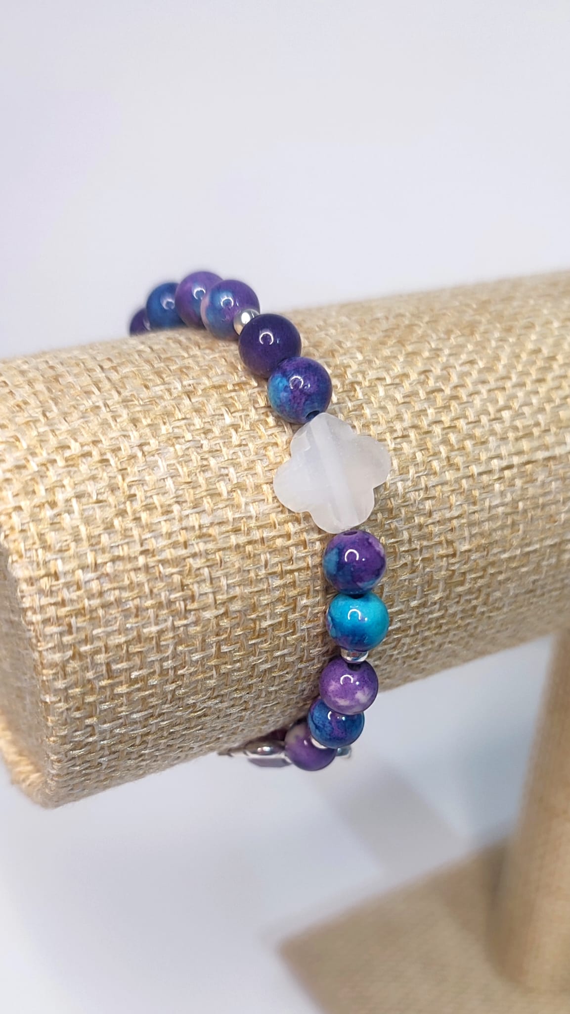 Pulsera en tonos violeta, púrpura con trébol de la suerte blanco