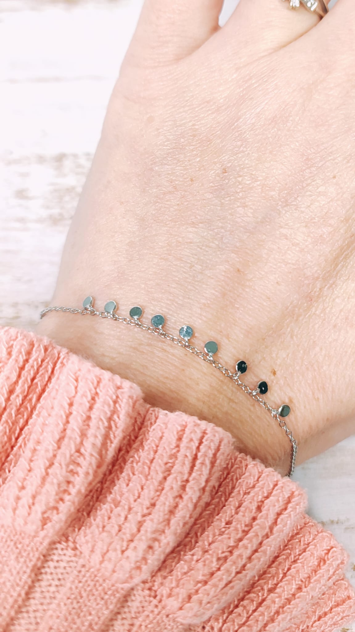 Vista en la muñeca de la pulsera con sus moneditas