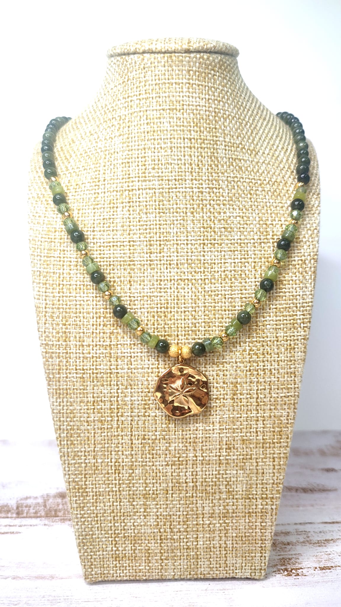 Collar de Minerales en tonos verde con medalla rustica dorada con flor en el centro