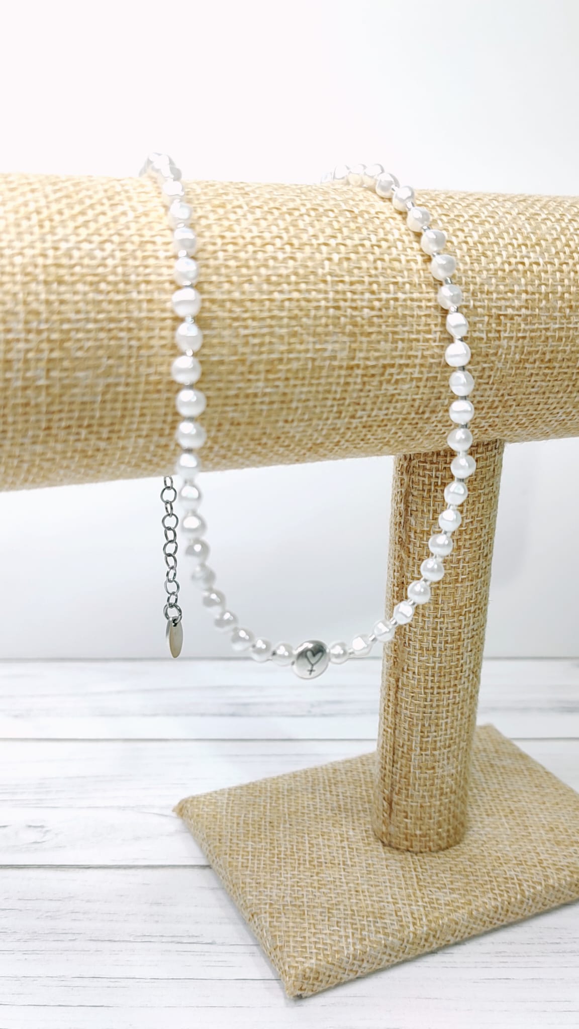 Collar de perlas blanco y adorno plateado con corazón y símbolo femenino